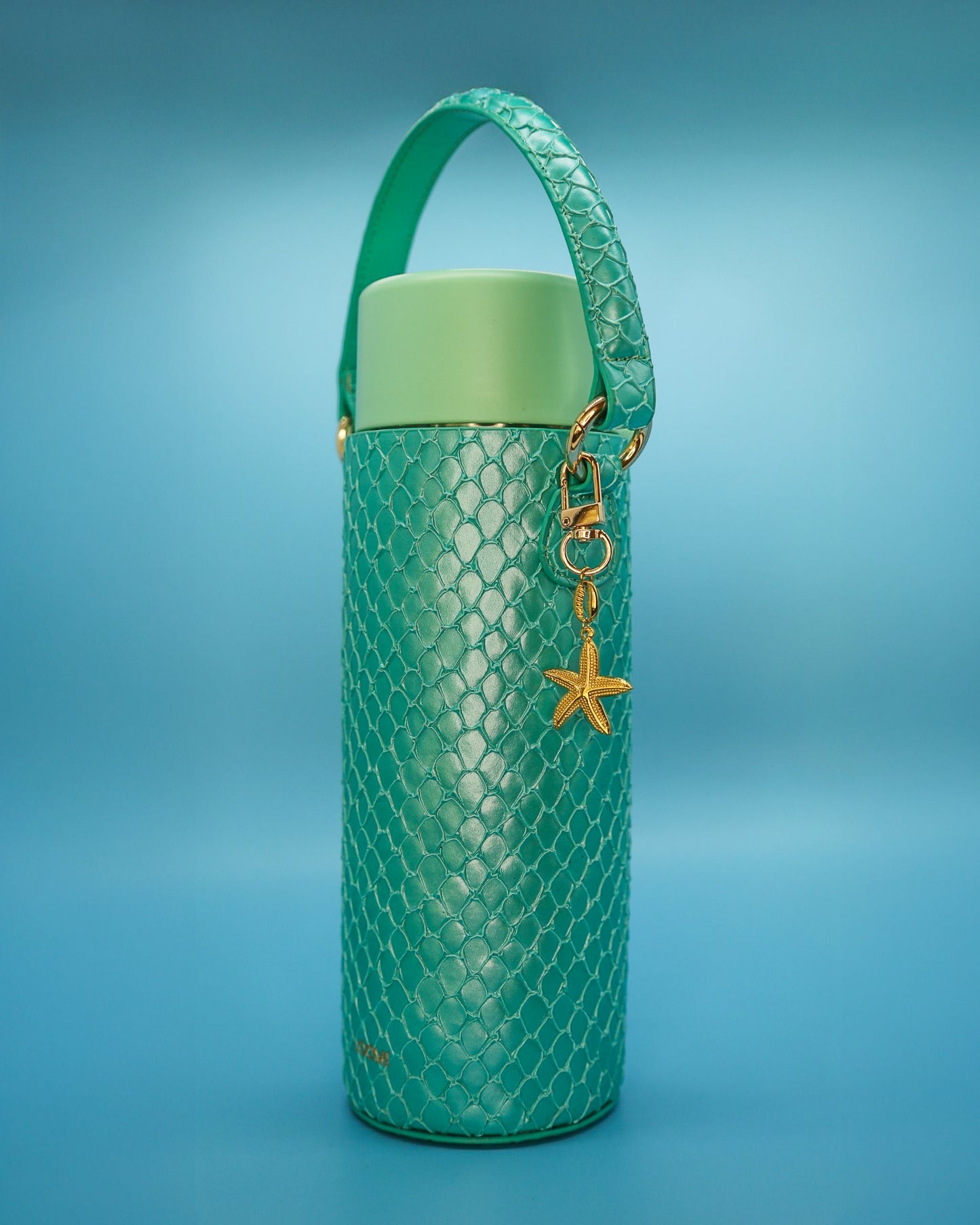 Gold starfish charm hanging from a mermaid-green Loomi water bottle Slip.