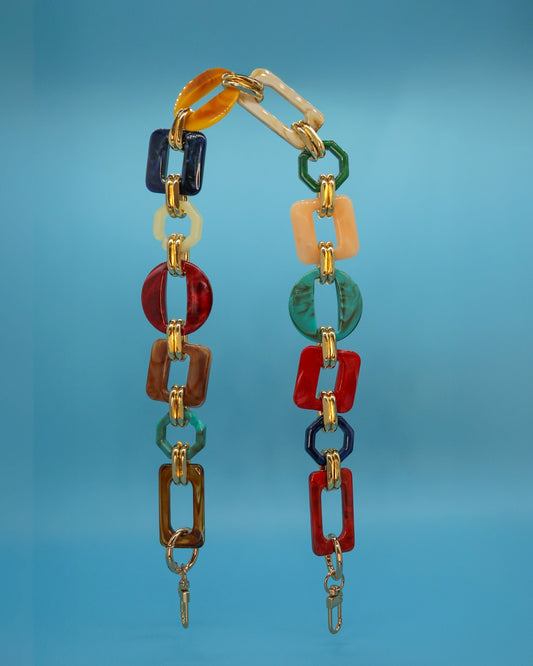 “Rectangular and round resin links in red, green, blue and amber on a chain strap.”