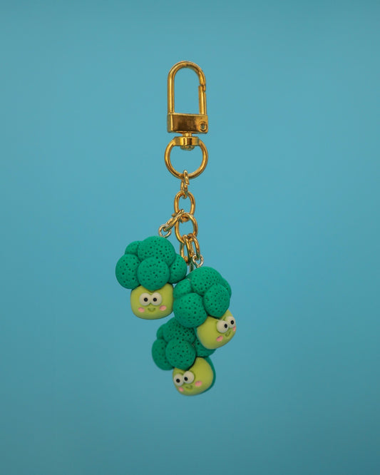 “Resin broccoli bottle charm with smiling faces and gold-tone clasp”